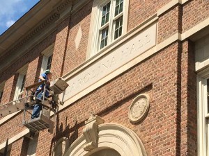 Workers place new "Carolina Hall" cap over "Saunders Hall" limestone